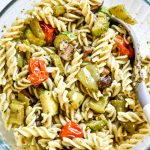 bowl of roasted veggie pesto pasta with a spoon